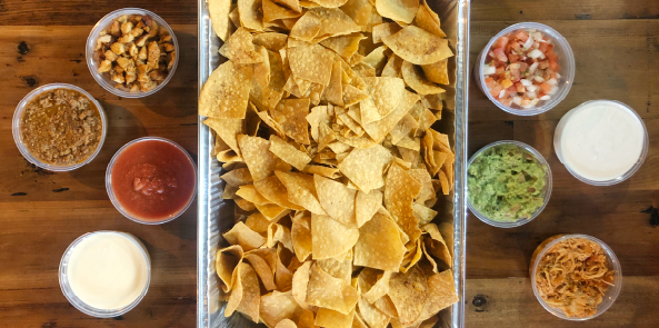 Overhead image of tortilla chips, salsas, queso, and guacamole at Sabor Latin Street Grill